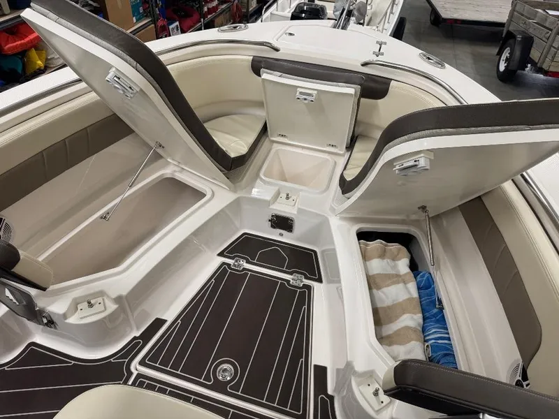 Slide: The Image of 2019 Robalo R242 Explorer boat interior with open storage compartments and cushioned seating. - 16