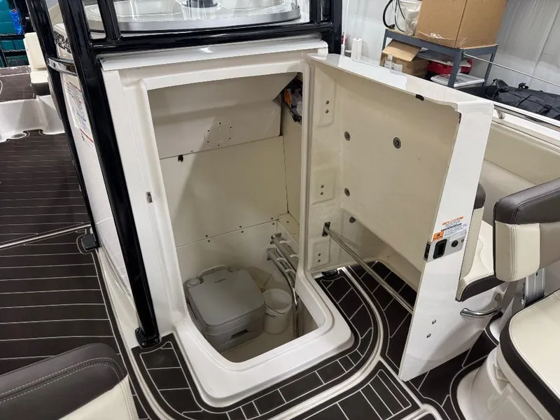 Slide: The Image of 2019 Robalo R242 Explorer boat interior with open storage compartment and toilet. - 18