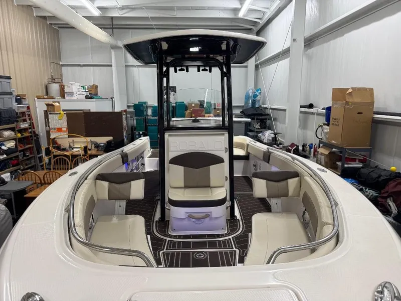 Slide: The Image of 2019 Robalo R242 Explorer boat interior in storage, featuring seating and console. - 19