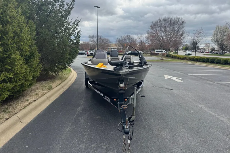 Slide: The Image of 2004 Tracker Tournament V-18 boat parked in a lot on a cloudy day. - 5