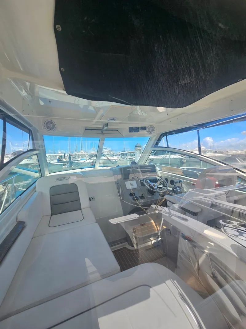 Slide: The Image of Interior view of 2013 Boston Whaler 315 Conquest boat with marina background. - 11