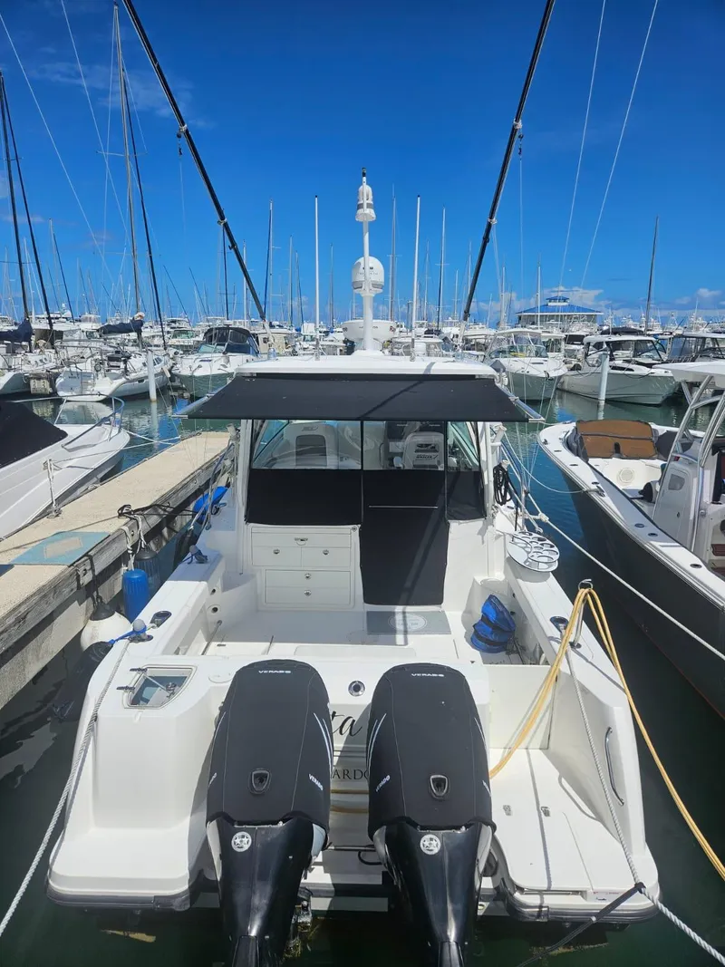 Slide: The Image of 2013 Boston Whaler 315 Conquest docked at a marina, featuring dual outboard engines. - 14