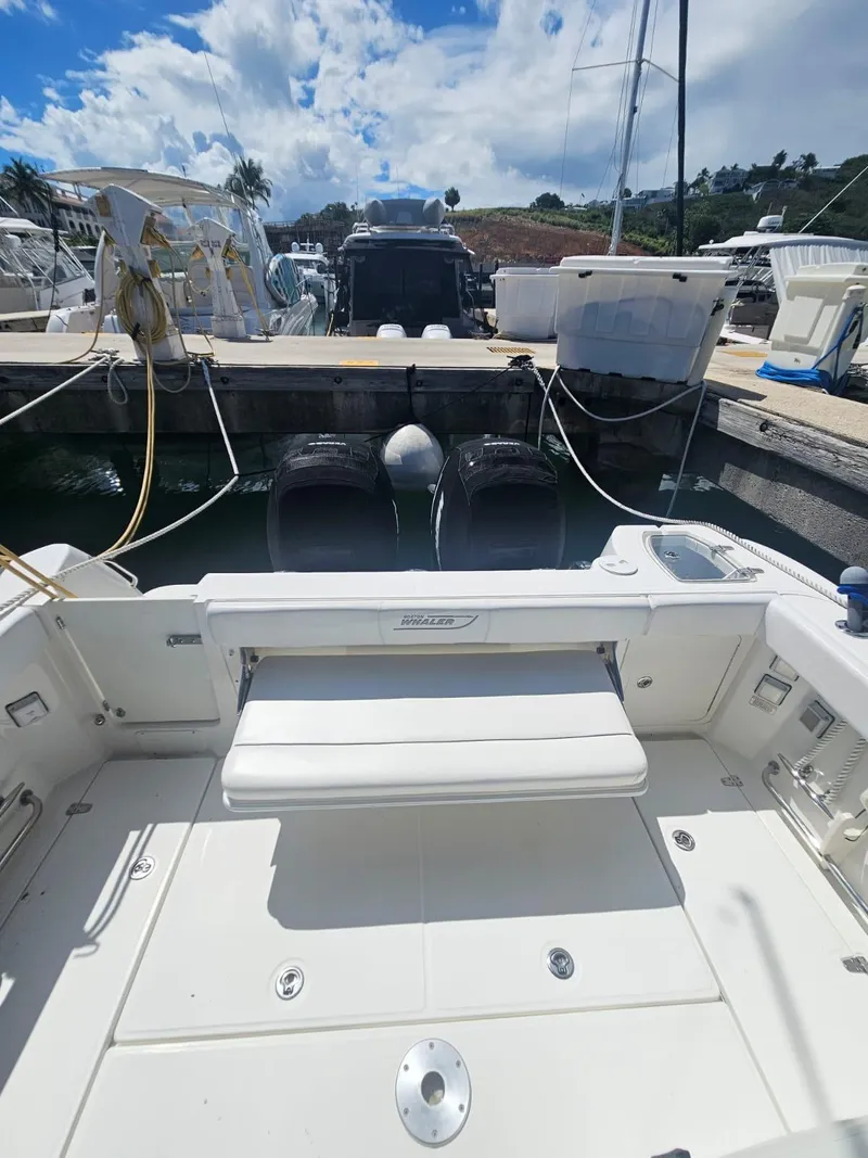 Slide: The Image of 2013 Boston Whaler 315 Conquest docked, showcasing spacious deck and dual engines. - 17