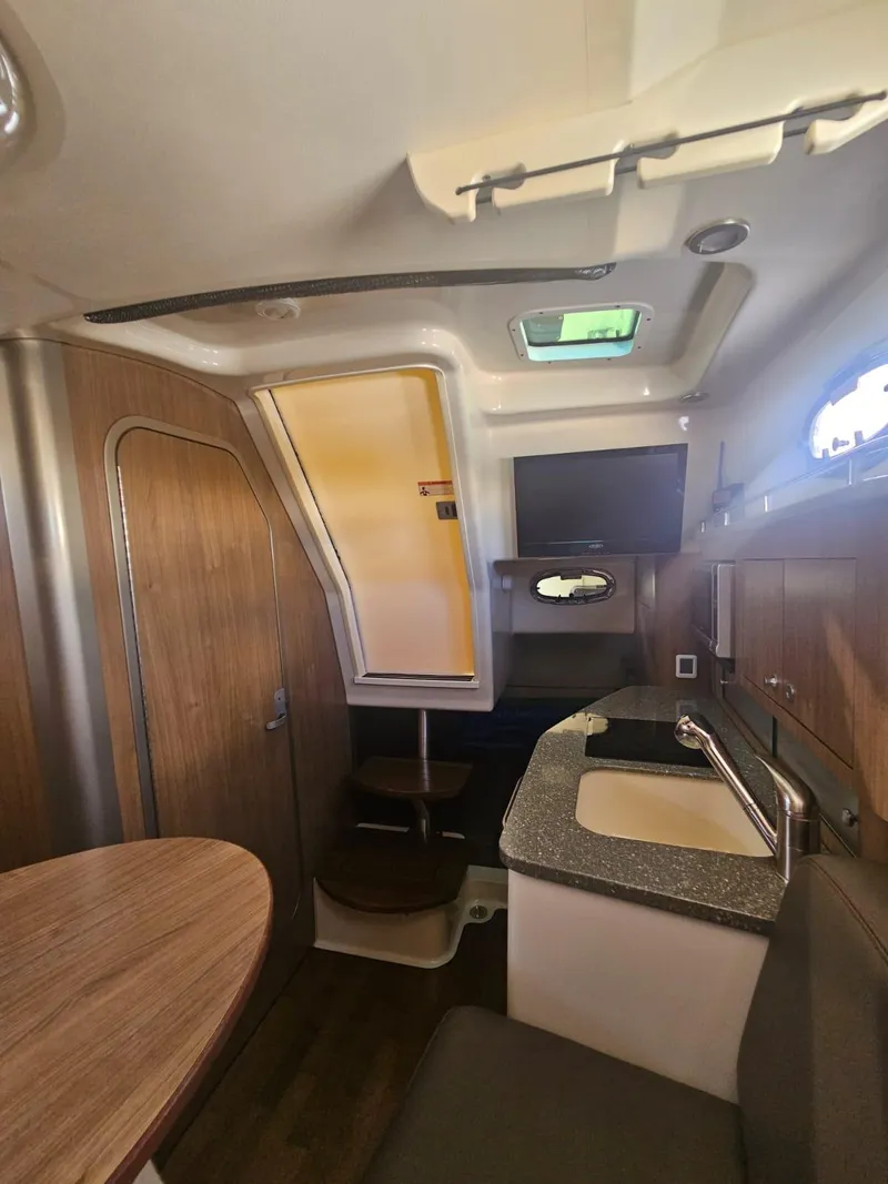 Slide: The Image of Interior of 2013 Boston Whaler 315 Conquest, featuring kitchenette and seating area. - 19