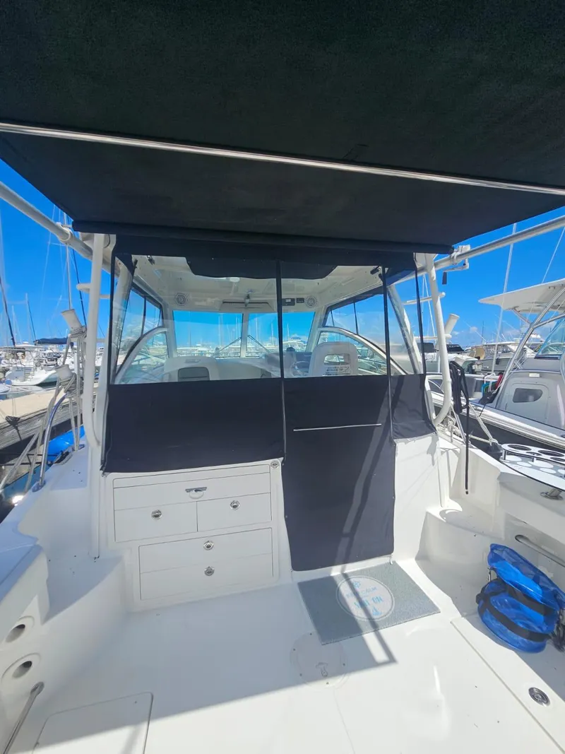 Slide: The Image of 2013 Boston Whaler 315 Conquest boat with covered cockpit, docked at marina. - 22