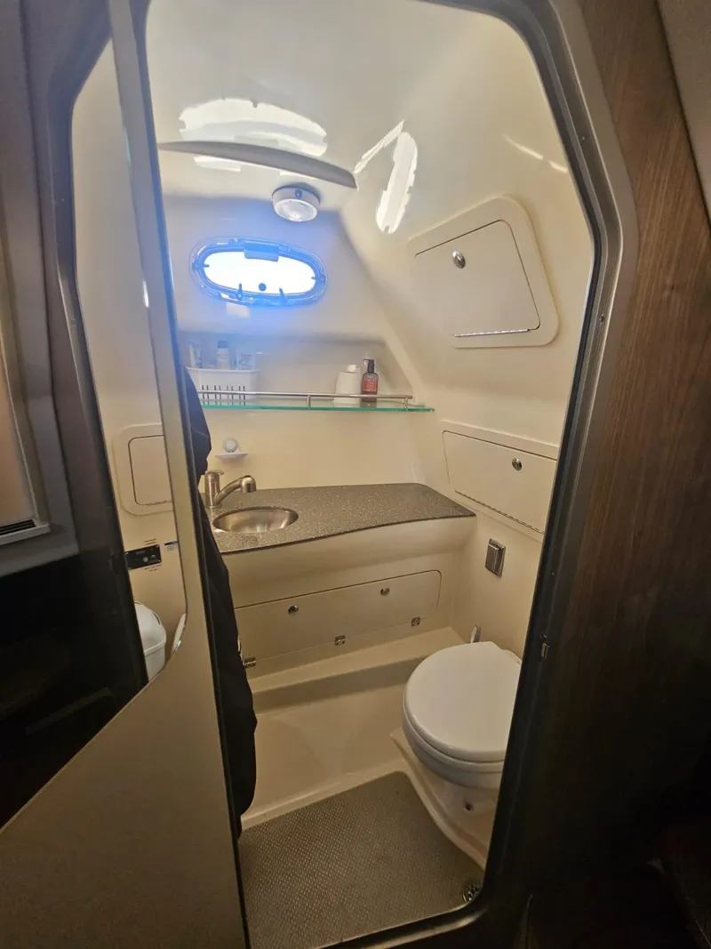 Slide: The Image of 2013 Boston Whaler 315 Conquest boat bathroom with sink, toilet, and storage. - 6
