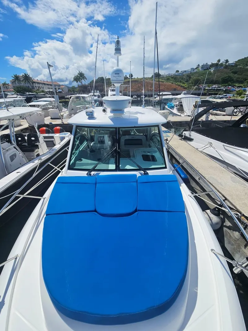 Slide: The Image of 2013 Boston Whaler 315 Conquest boat docked in a marina under a blue sky. - 8