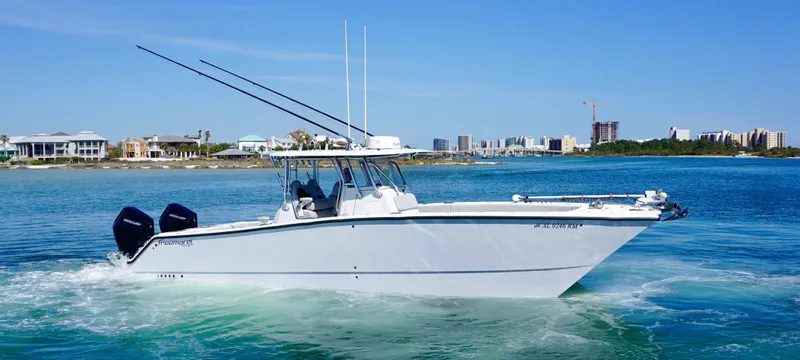 Slide: The Image of 2020 Freeman VH boat cruising on clear blue water near a coastal cityscape. - 0