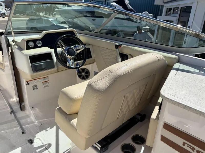 Slide: The Image of 2018 Regal 26 OBX boat interior with beige seating and steering wheel. - 12