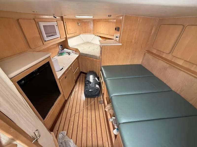 Slide: The Image of 2005 Out Island 38 Express Fisherman cabin with wooden interior and green seating. - 12