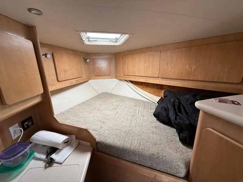 Slide: The Image of 2005 Out Island 38 Express Fisherman cabin interior with bed and wooden cabinetry. - 13