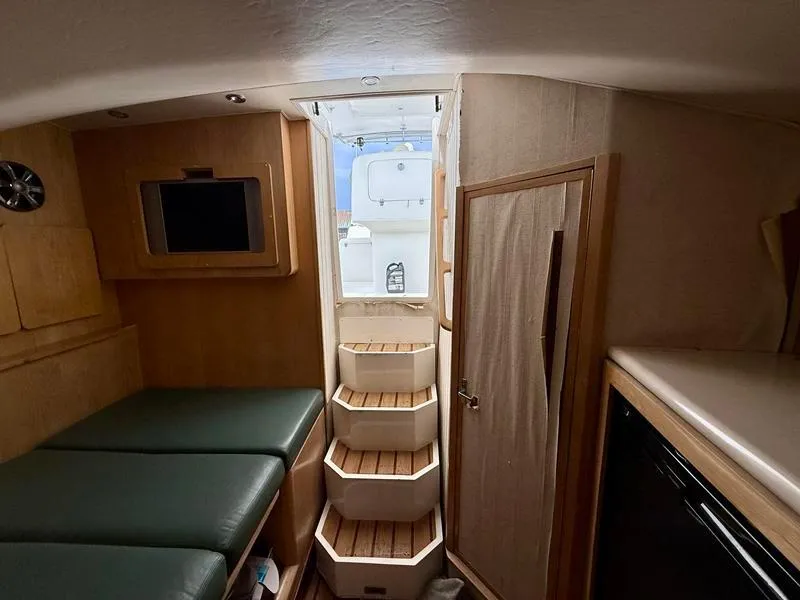 Slide: The Image of 2005 Out Island 38 Express Fisherman cabin interior with steps, seating, and storage. - 15