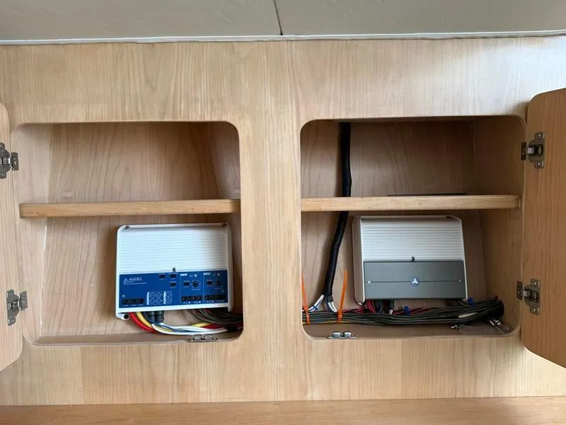 Slide: The Image of Electrical components inside a wooden cabinet on a 2005 Out Island 38 Express Fisherman boat. - 17