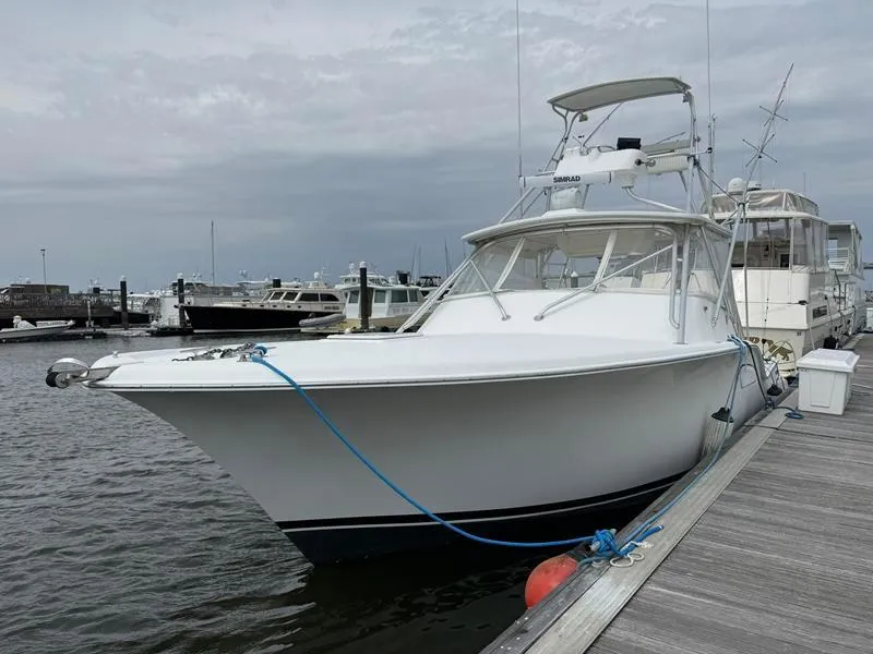 Slide: The Image of 2005 Out Island 38 Express Fisherman boat docked at marina, overcast sky. - 2
