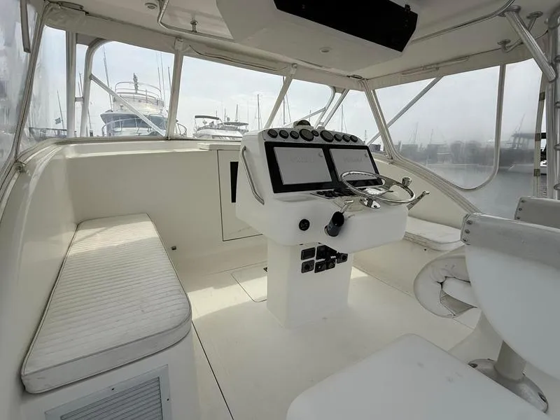 Slide: The Image of 2005 Out Island 38 Express Fisherman cockpit with helm, seating, and marina view. - 6