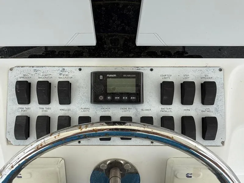 Slide: The Image of Control panel of 2005 Out Island 38 Express Fisherman boat with various switches and a Fusion stereo. - 9