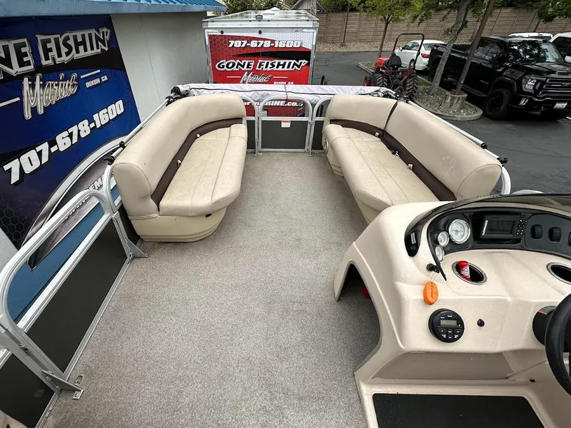 Slide: The Image of 2019 Sun Tracker Party Barge 18 DLX interior with beige seating and control console. - 10