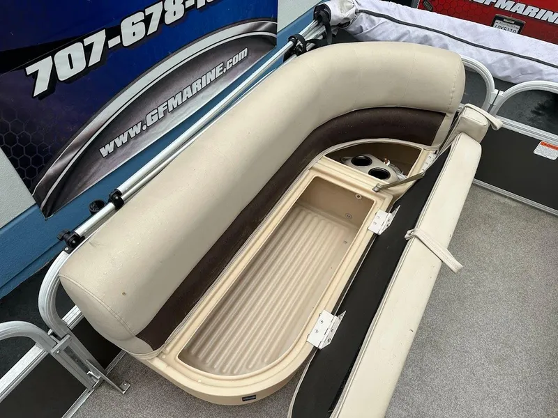 Slide: The Image of 2019 Sun Tracker Party Barge 18 DLX with open storage compartment and beige seating. - 16