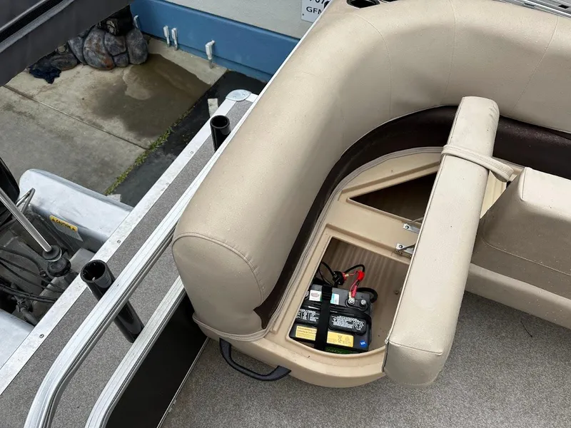 Slide: The Image of 2019 Sun Tracker Party Barge 18 DLX with open storage compartment and battery. - 18