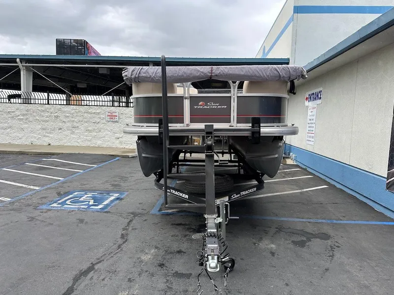 Slide: The Image of 2019 Sun Tracker Party Barge 18 DLX pontoon boat on trailer in parking lot. - 2