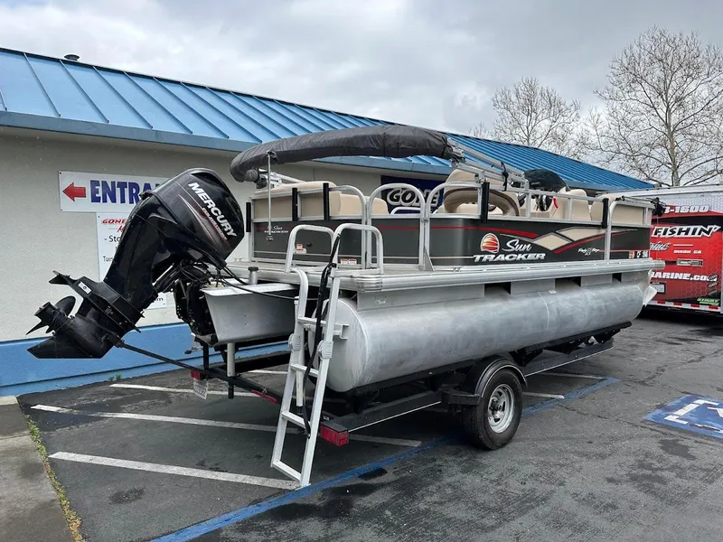 Slide: The Image of 2019 Sun Tracker Party Barge 18 DLX pontoon boat on trailer, parked outdoors. - 4