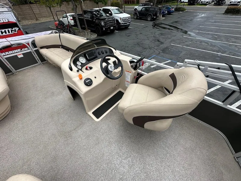 Slide: The Image of 2019 Sun Tracker Party Barge 18 DLX interior with beige seating and steering console. - 8