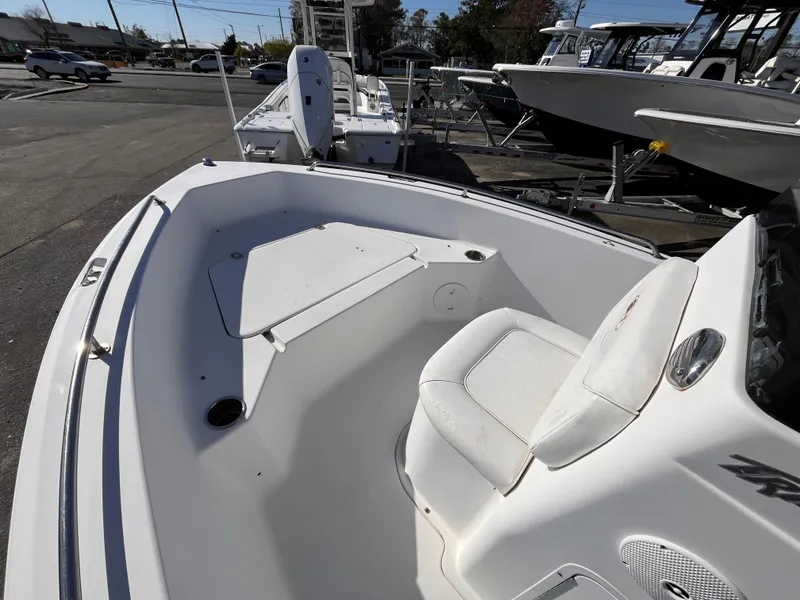 Slide: The Image of 2010 Sea Hunt Triton 177 boat interior with seating and storage, docked outdoors. - 10