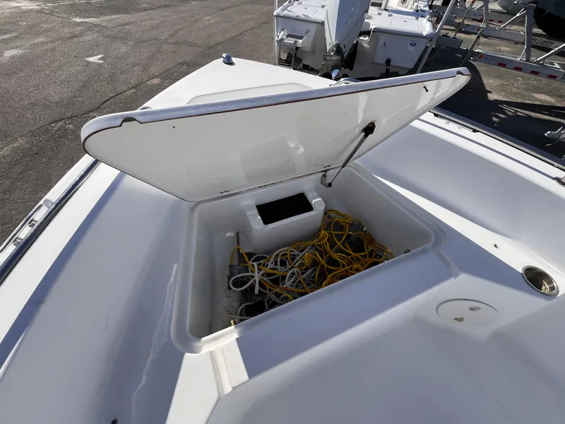 Slide: The Image of 2010 Sea Hunt Triton 177 boat storage compartment with open lid and coiled ropes inside. - 13