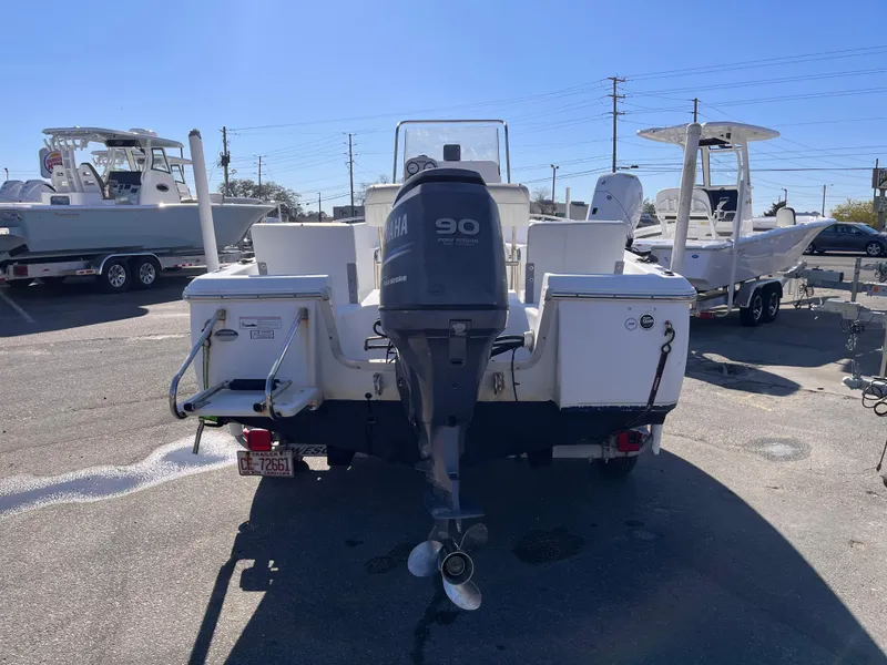 Slide: The Image of 2010 Sea Hunt Triton 177 boat with Yamaha 90 outboard motor, parked in a marina. - 4