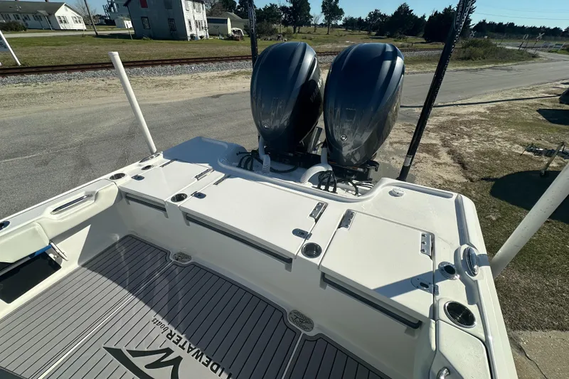 Slide: The Image of 2023 Tidewater 2700 Carolina Bay boat with dual outboard motors, docked on a sunny day. - 11