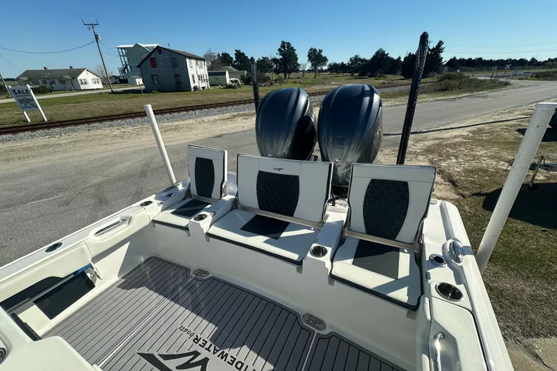 Slide: The Image of 2023 Tidewater 2700 Carolina Bay boat with dual engines, docked on a sunny day. - 12