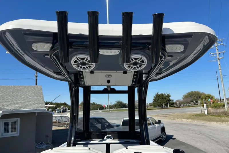 Slide: The Image of 2023 Tidewater 2700 Carolina Bay boat with T-top and rod holders, parked outdoors. - 21