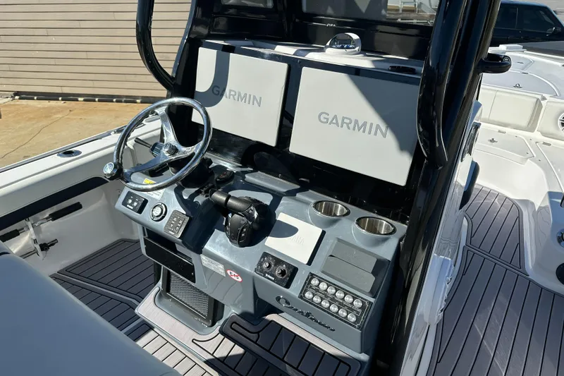 Slide: The Image of 2023 Tidewater 2700 Carolina Bay boat console with Garmin displays and steering wheel. - 23
