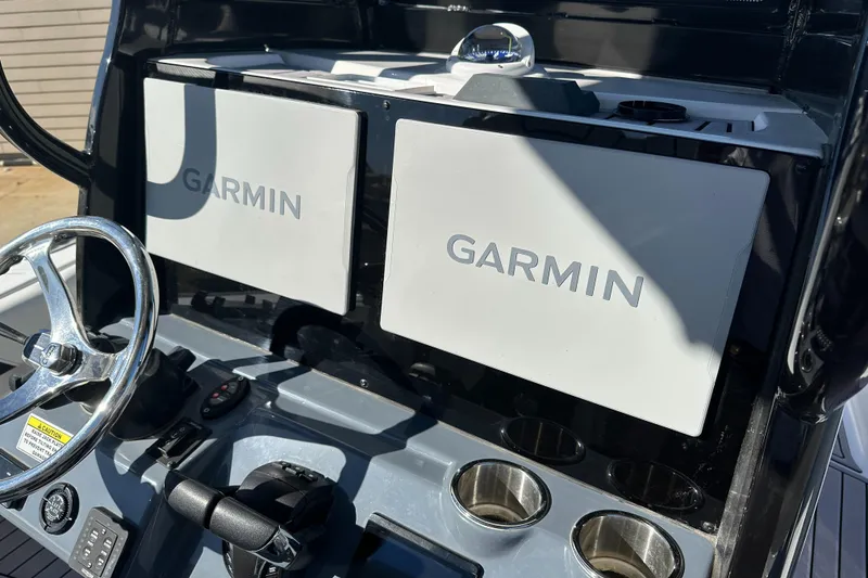 Slide: The Image of 2023 Tidewater 2700 Carolina Bay dashboard with dual Garmin displays and steering wheel. - 29