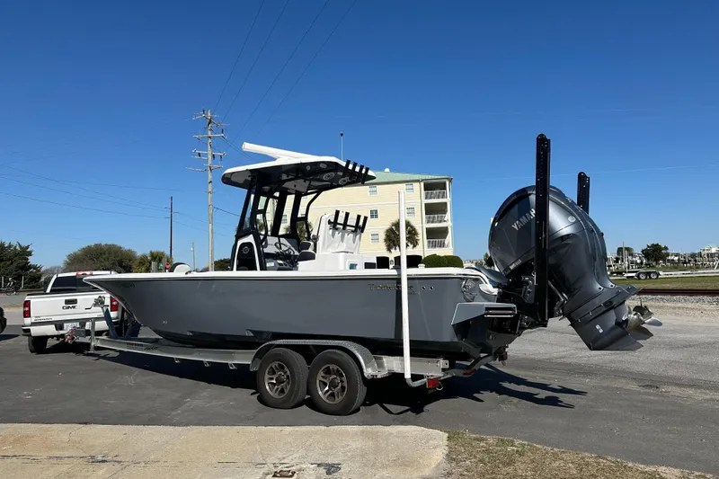 Slide: The Image of 2023 Tidewater 2700 Carolina Bay boat on trailer, parked outdoors under clear blue sky. - 3