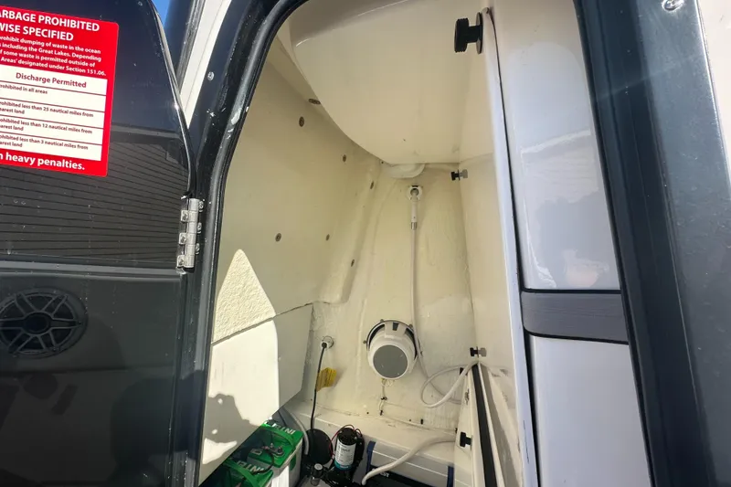 Slide: The Image of 2023 Tidewater 2700 Carolina Bay interior storage compartment with equipment and warning sign. - 50