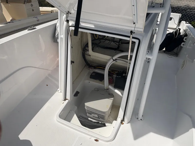 Slide: The Image of 2022 Wellcraft 202 Fisherman boat storage compartment with open hatch and visible equipment. - 10