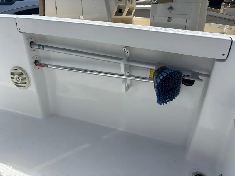 Slide: The Image of 2022 Wellcraft 202 Fisherman boat interior with cleaning brush and storage rods. - 16