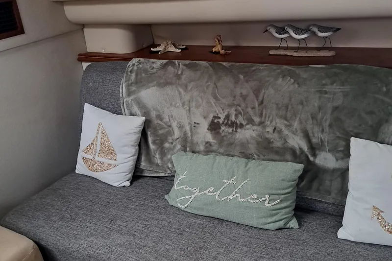 Slide: The Image of 1999 Cruisers aft cabin interior with decorative pillows and nautical-themed decor. - 1
