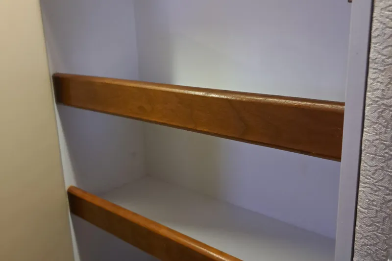 Slide: The Image of 1999 Cruisers aft cabin interior with wooden shelves. - 10