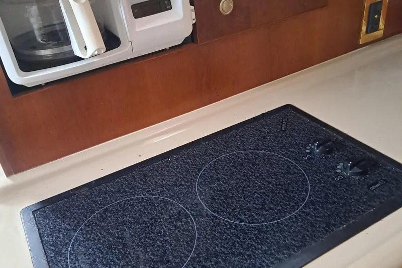 Slide: The Image of 1999 Cruisers aft cabin kitchen with stovetop and built-in coffee maker. - 2