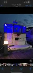 Slide: The Image of 1999 Cruisers aft cabin boat docked at night with blue lighting. - 20