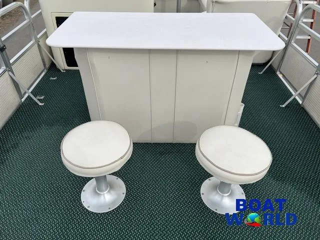 Slide: The Image of Two white stools and a bar on a Weeres Sundeck 280 boat. - 16