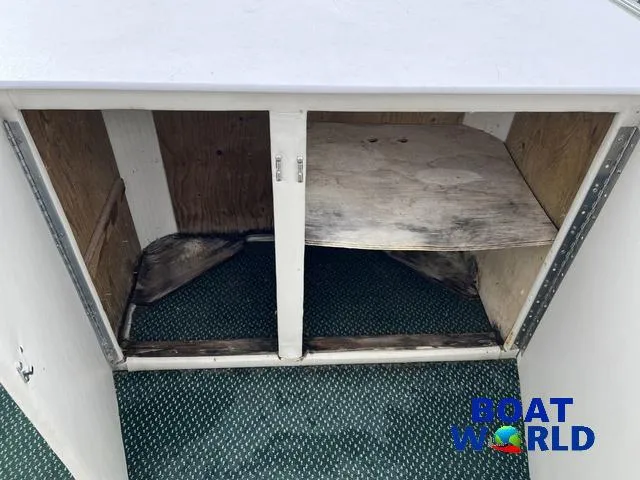 Slide: The Image of Open storage compartment on Weeres Sundeck 280 boat, showing interior shelving and wear. - 19