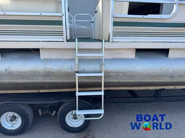 Slide: The Image of Open storage compartment on Weeres Sundeck 280 TT boat, featuring green carpet and "Boat World" logo. - 21
