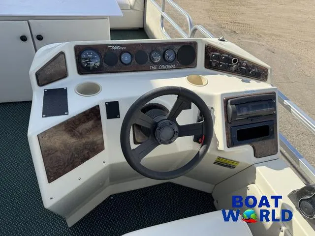 Slide: The Image of Weeres Sundeck 280 with 2021 Honda 100HP engine, open storage compartment, Boat World logo. - 24