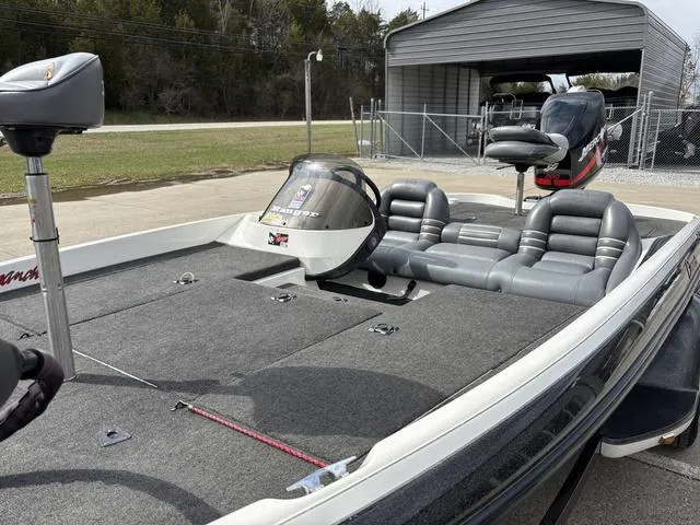 Slide: The Image of 2001 Ranger 518VX fishing boat with gray seating and trolling motor, parked near a garage. - 9