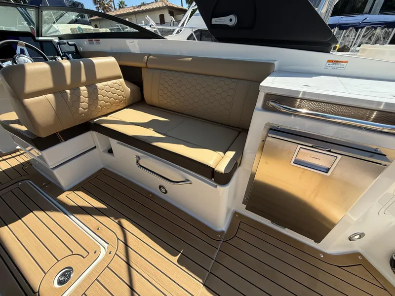 Slide: The Image of 2022 Sea Ray 290 SDX OB boat interior with tan seating and stainless steel accents. - 11