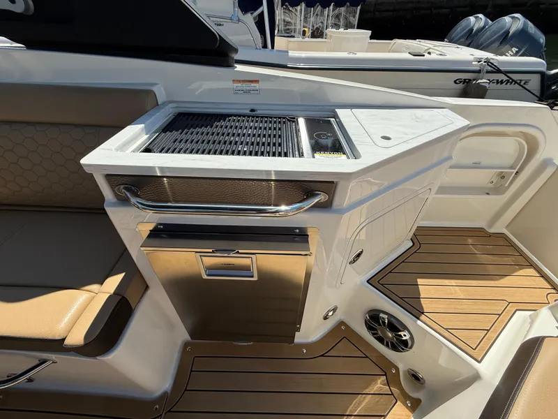 Slide: The Image of 2022 Sea Ray 290 SDX OB boat interior with grill and seating area. - 12