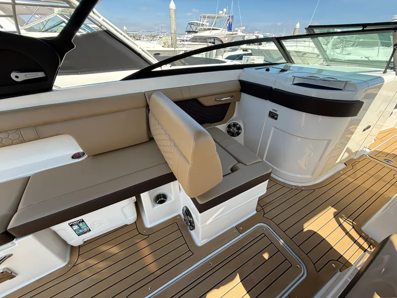 Slide: The Image of 2022 Sea Ray 290 SDX OB boat interior with tan seating and wooden deck. - 14